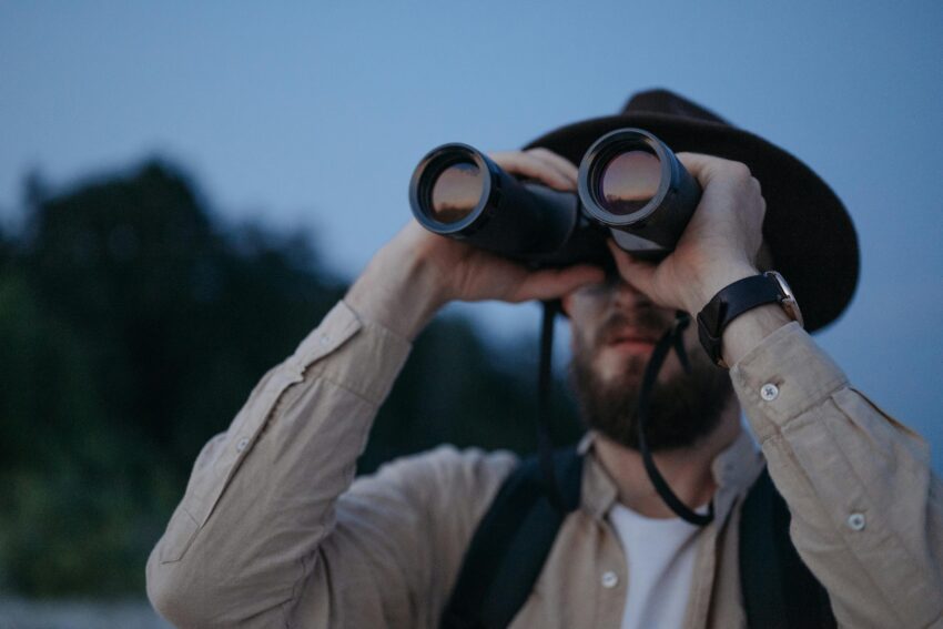 Bearded Man Looking through Binoculars at Dawn